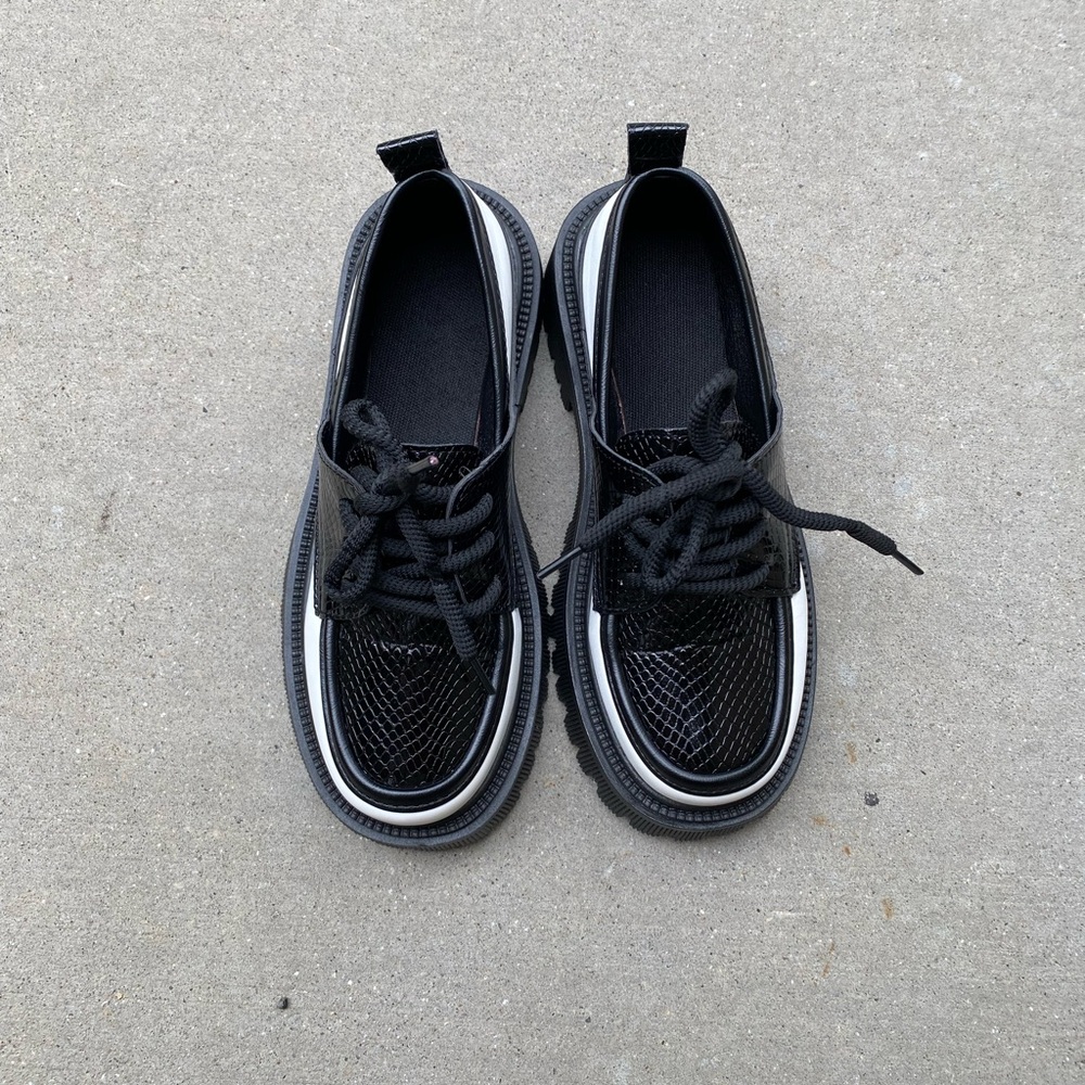 Black and white Oxford style shoes.